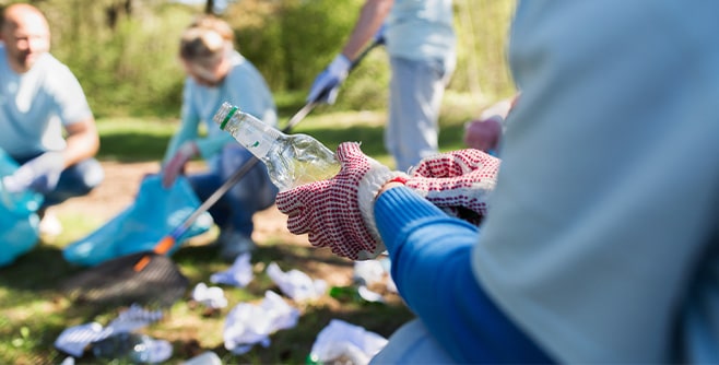 volunteer-with-trash-bag-and-bottle-cleaning-area